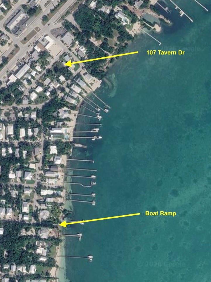 An aerial map view showing a residential neighborhood along a coastline with private boat docks — TAVERNIER, FL