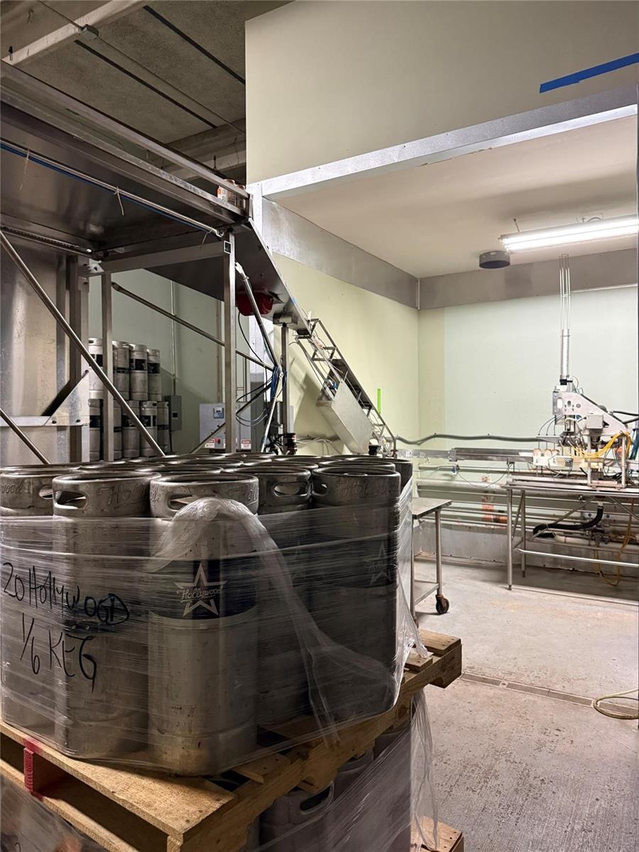 A pallet of stacked metal kegs sits in a commercial industrial space with processing equipment — 3410 29th Avenue, Hollywood FL 33020, HOLLYWOOD, FL