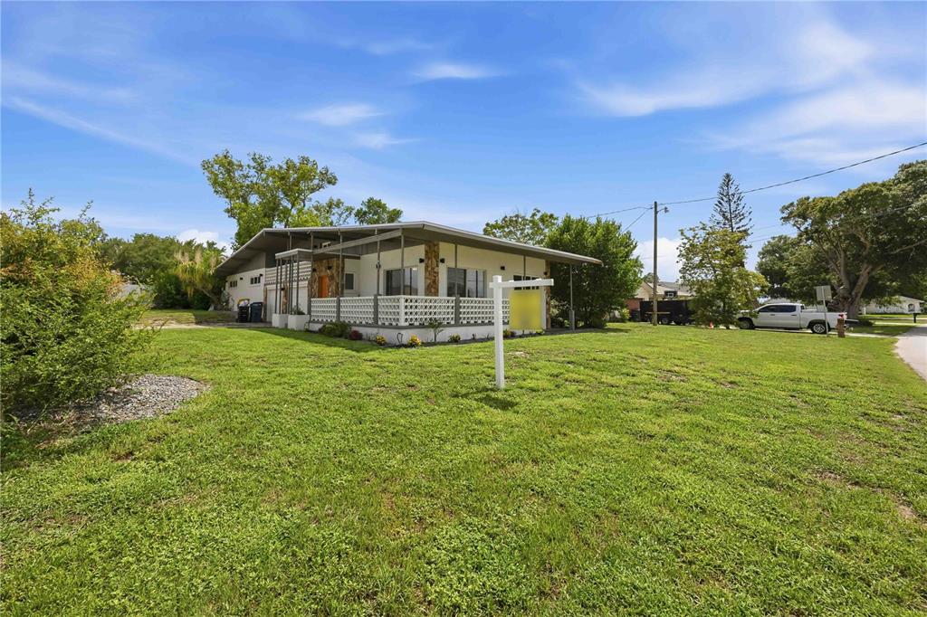 A single-story house with a covered porch and stone accents sits on a grassy lot — 6704 WINTERSET GARDENS ROAD, WINTER HAVEN, FL