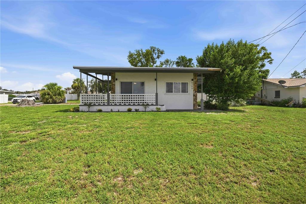 A single-story house with a covered front porch and a large grassy yard — 6704 WINTERSET GARDENS ROAD, WINTER HAVEN, FL