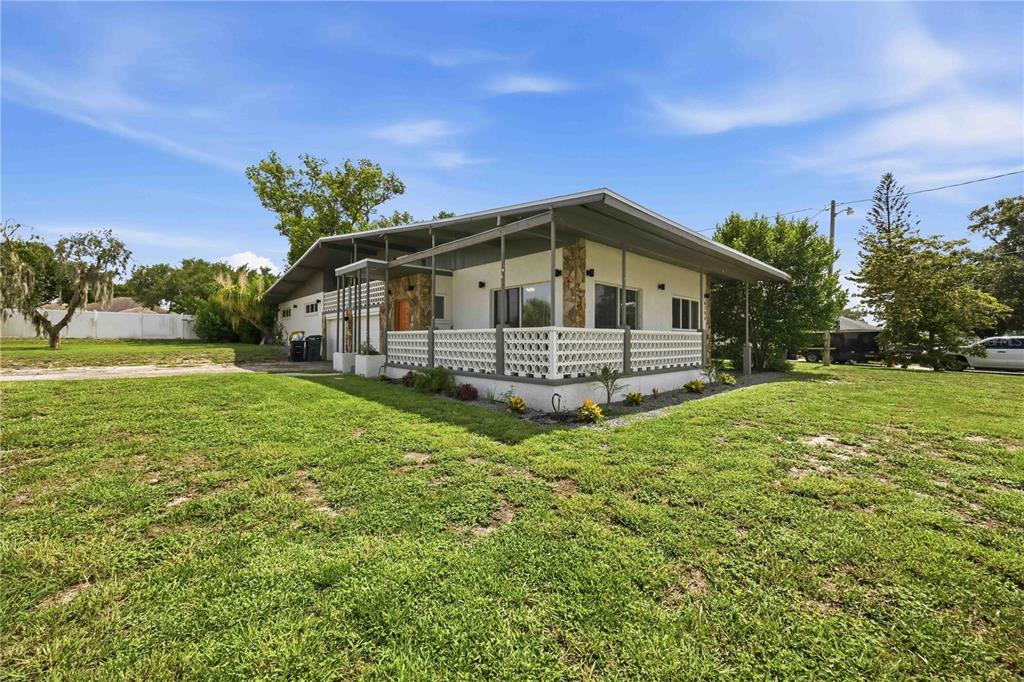 A single-story house with a covered porch and decorative white railing sits on a lawn — 6704 WINTERSET GARDENS ROAD, WINTER HAVEN, FL