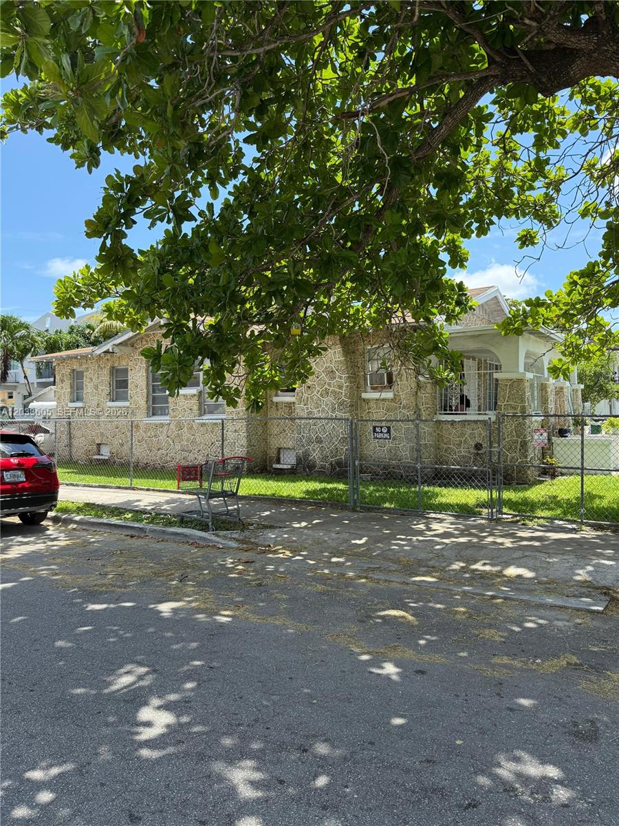 A single-story house with a stone exterior sits behind a chain-link fence — 1269 NW 4th St, Miami FL 33125, MIAMI, FL
