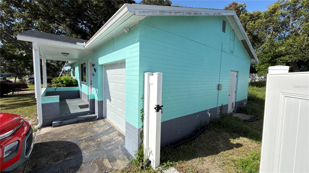 A teal and gray exterior of a house with a garage and a small porch — 856 BERKSHIRE ROAD, DAYTONA BEACH, FL