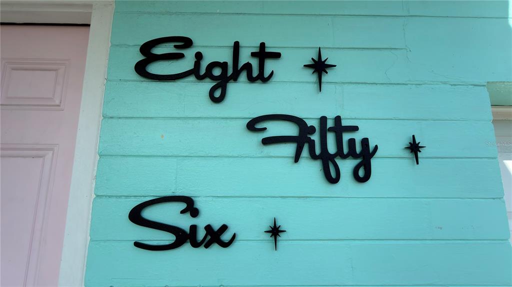 The words Eight Fifty Six are mounted on a light blue horizontal-plank exterior wall — 856 BERKSHIRE ROAD, DAYTONA BEACH, FL
