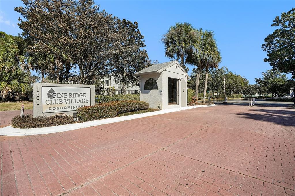 The entrance to Pine Ridge Club Village features a brick driveway and a guardhouse — 1013 S PINE RIDGE CIRCLE UNIT 3C, SANFORD, FL