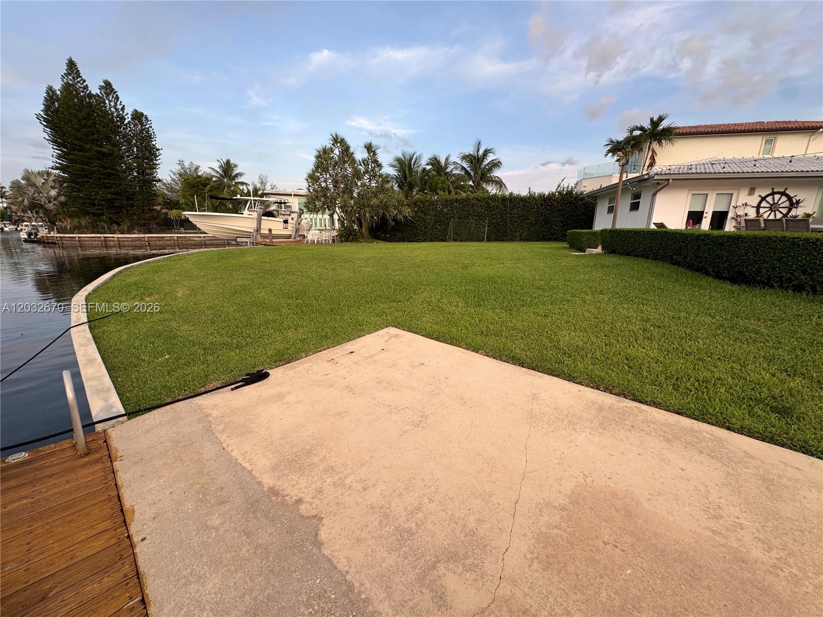 An aerial view shows a vacant waterfront lot situated between two houses along a canal — 13305 Biscayne Island Ter, North Miami FL 33181, NORTH MIAMI, FL