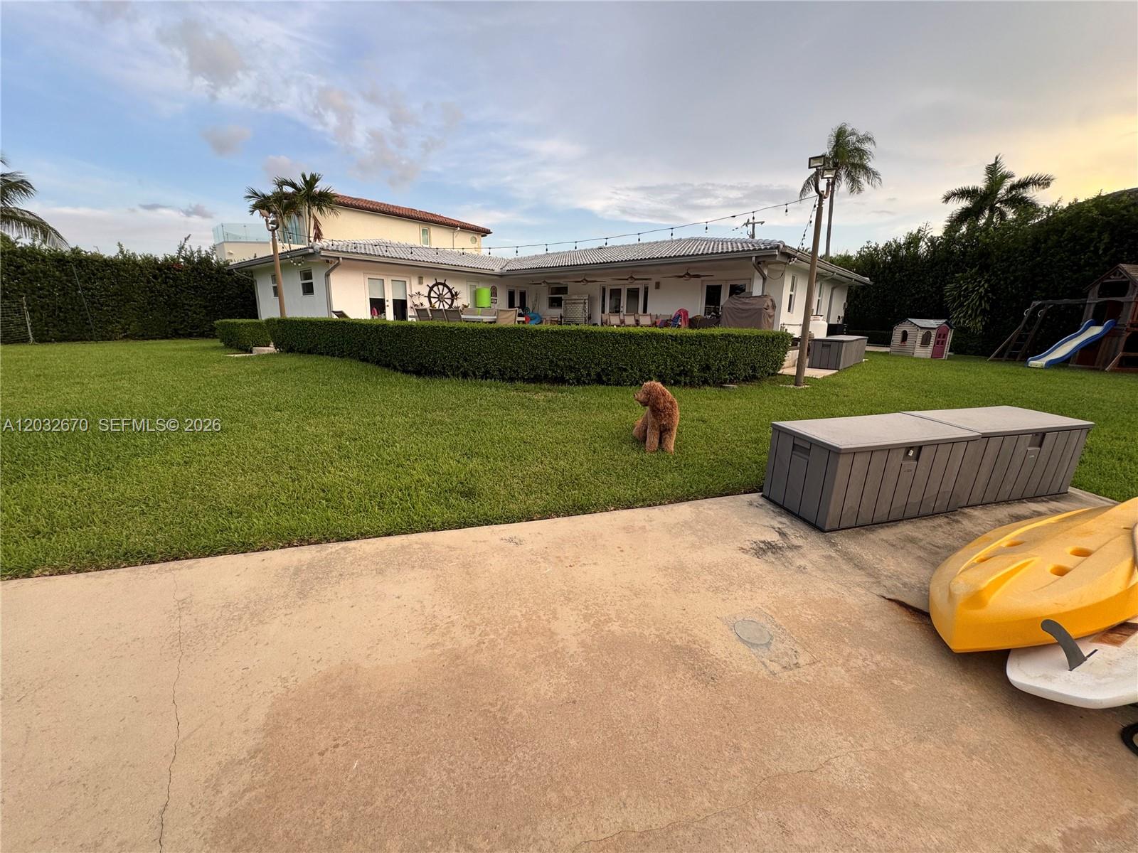An aerial view shows a waterfront house with a pool, lawn, and docked boats — 13305 Biscayne Island Ter, North Miami FL 33181, NORTH MIAMI, FL