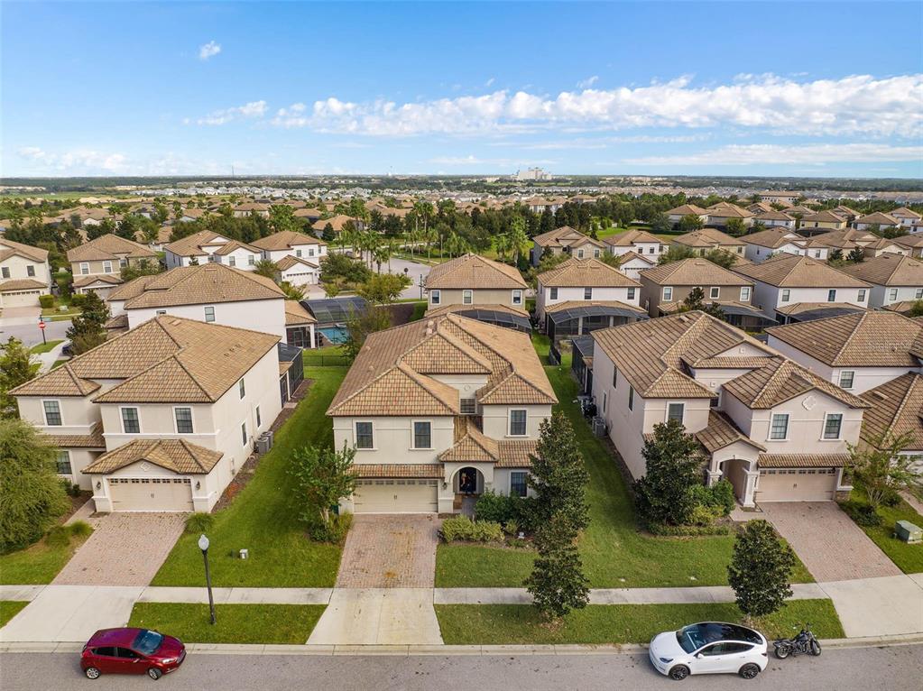 An aerial view of suburban houses with tiled roofs and driveways on a sunny day — 1453 BELLE TERRE ROAD, DAVENPORT, FL