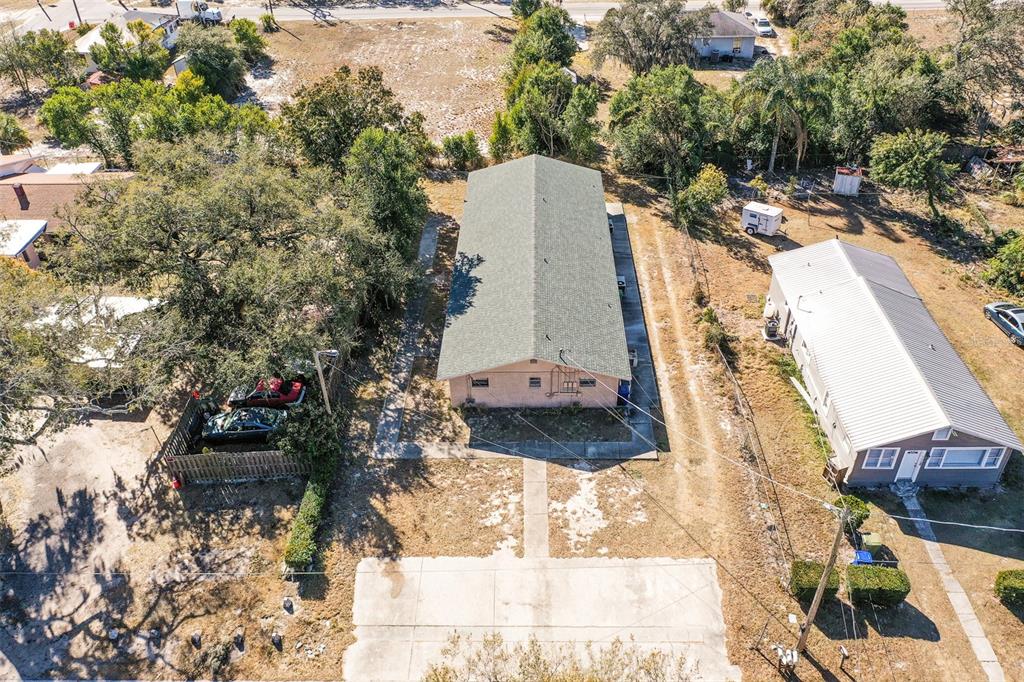 An aerial view shows a rectangular house with a green roof between two properties — 140 AVENUE W NW UNIT 3, WINTER HAVEN, FL