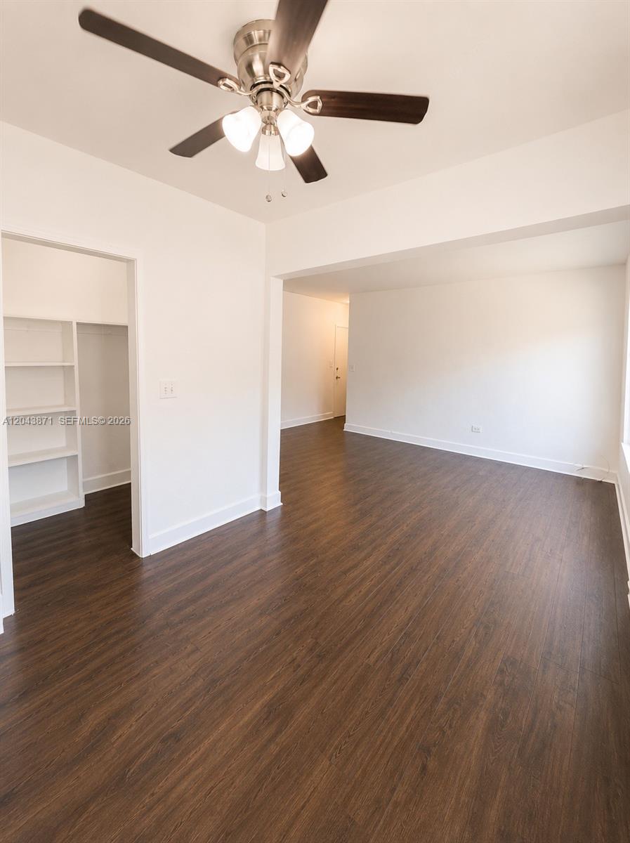 A room with dark wood-look flooring, white walls, a ceiling fan, and an open closet — 322 25th St # 12, Miami Beach FL 33140, MIAMI BEACH, FL