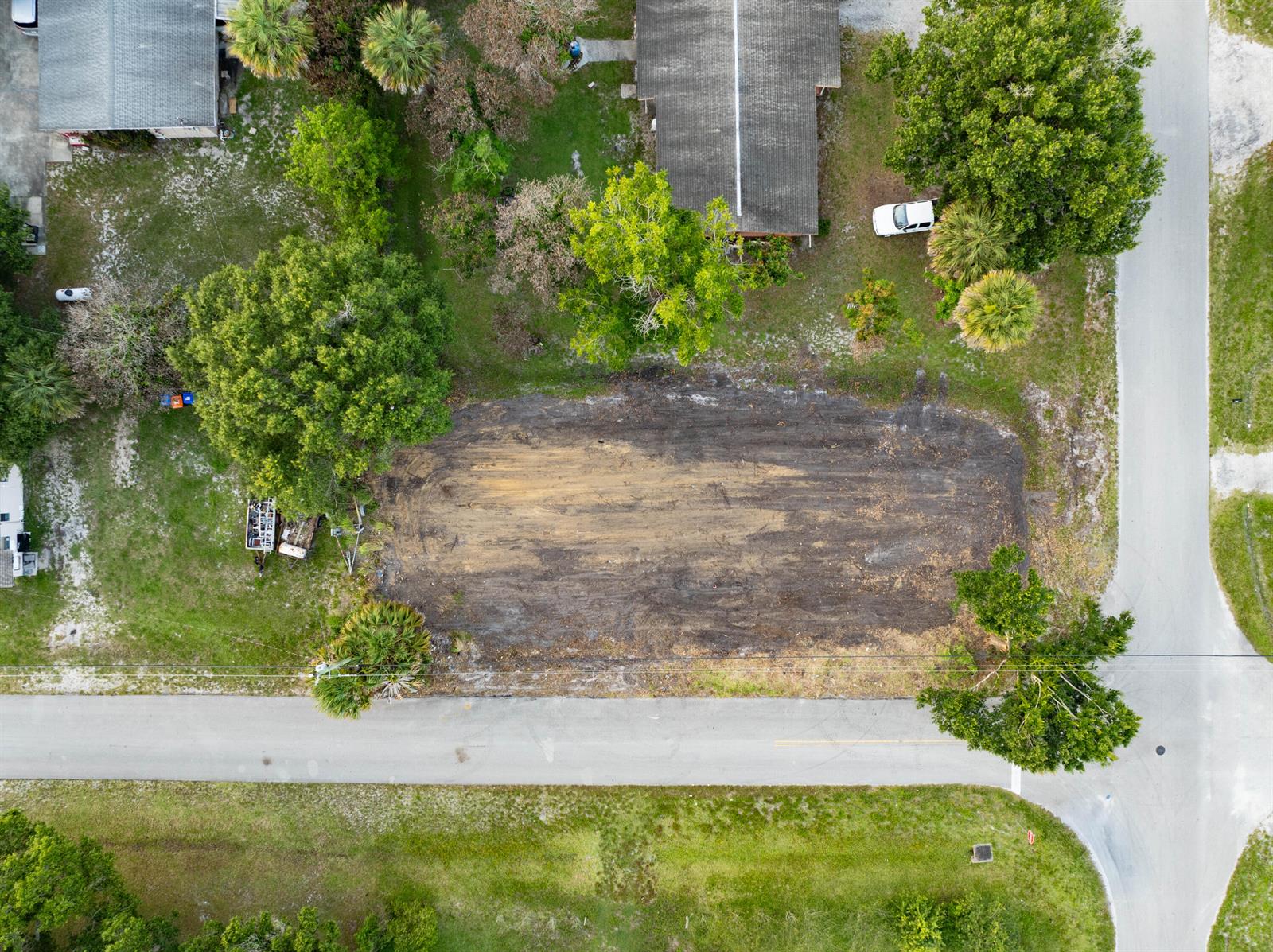 An aerial view shows a cleared, rectangular dirt lot situated between two residential properties — 4805 34th Avenue, Vero Beach FL 32967, VERO BEACH, FL