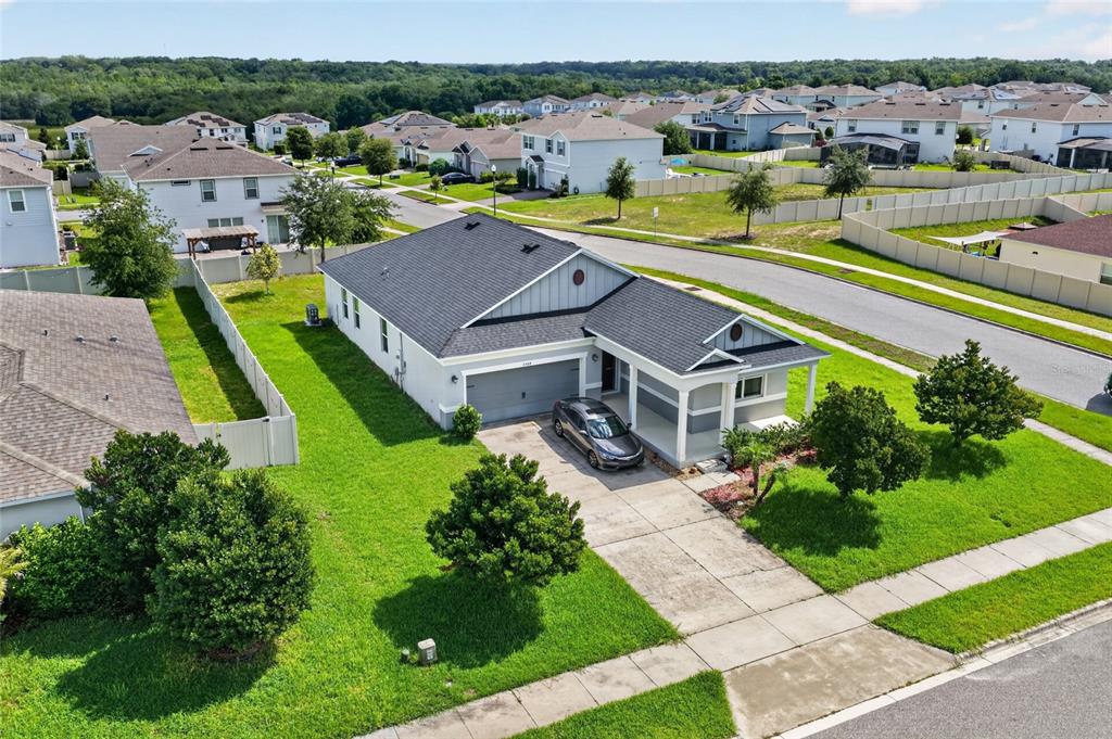 An aerial view shows a single-story suburban house with a gray roof and driveway — 2364 CARRIAGE POINTE LOOP, APOPKA, FL