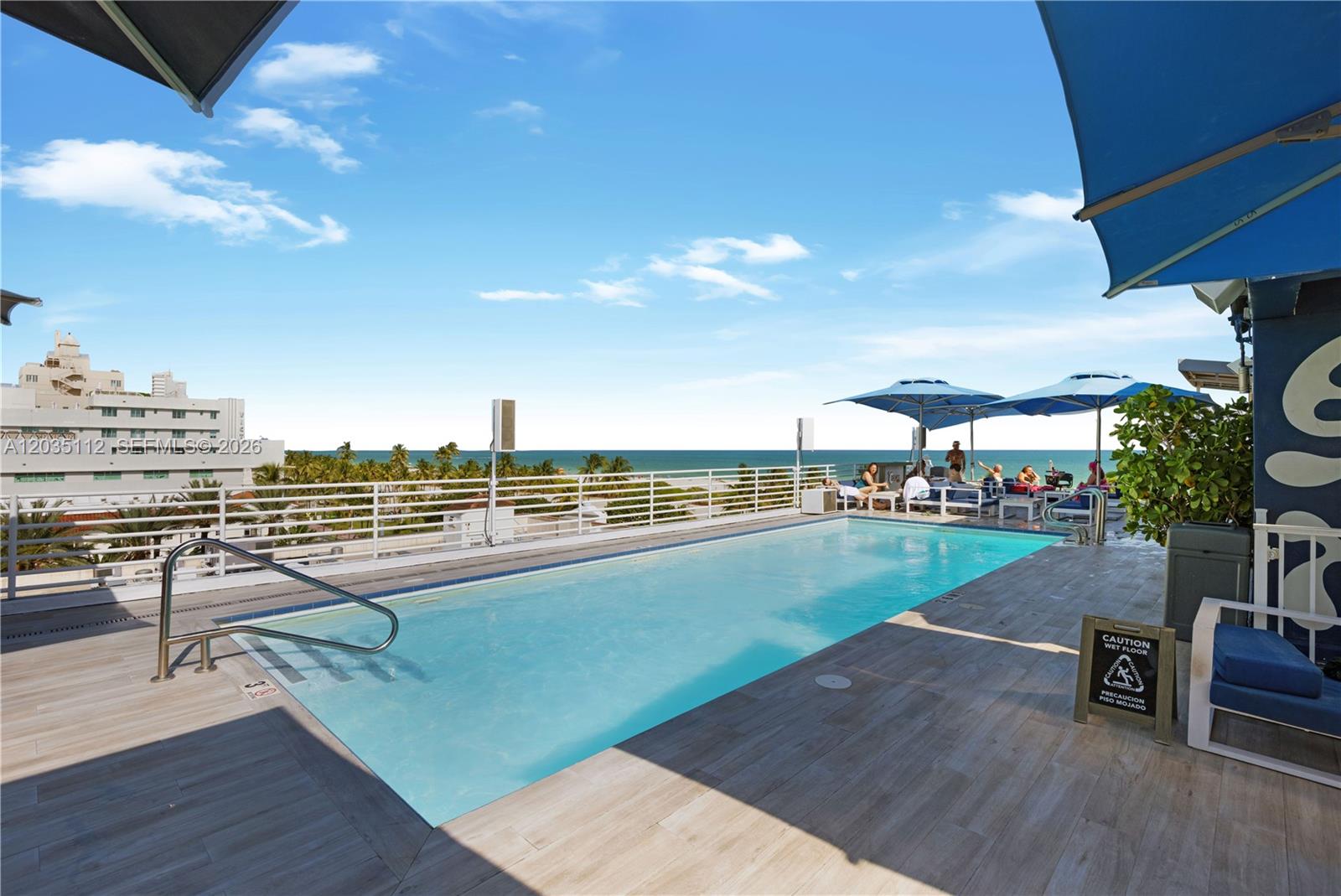 A rooftop swimming pool overlooks the ocean with lounge chairs and umbrellas on the deck — 1024 Ocean Dr # A402, Miami Beach FL 33139, MIAMI BEACH, FL