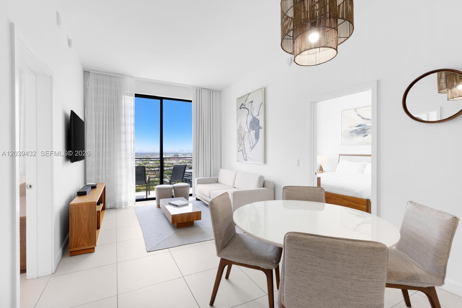 A bright living and dining area features white tile floors, modern furniture, and balcony access — 5350 NW 84th Ave # 2007, Doral FL 33166, DORAL, FL