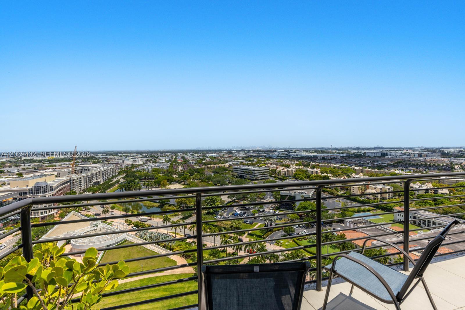 A high-rise balcony with metal railings overlooks a suburban landscape with buildings and greenery — 5350 NW 84th Ave # 2007, Doral FL 33166, DORAL, FL