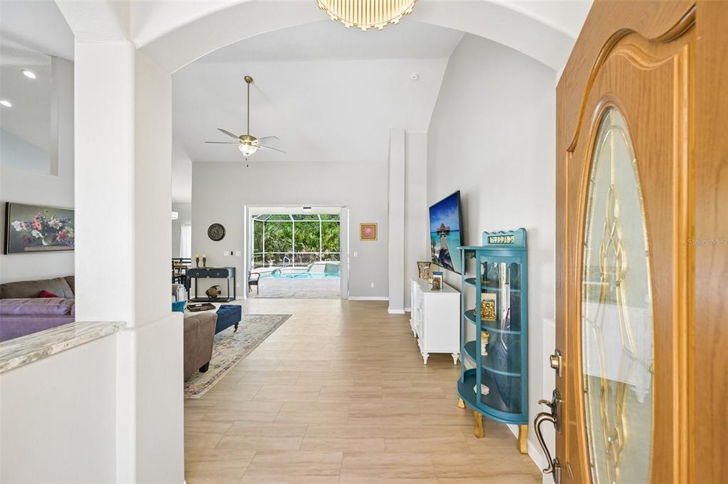 An entryway leads into a living room with tile flooring, a pool view, and furniture — 546 SEVILLA DRIVE, ST AUGUSTINE, FL