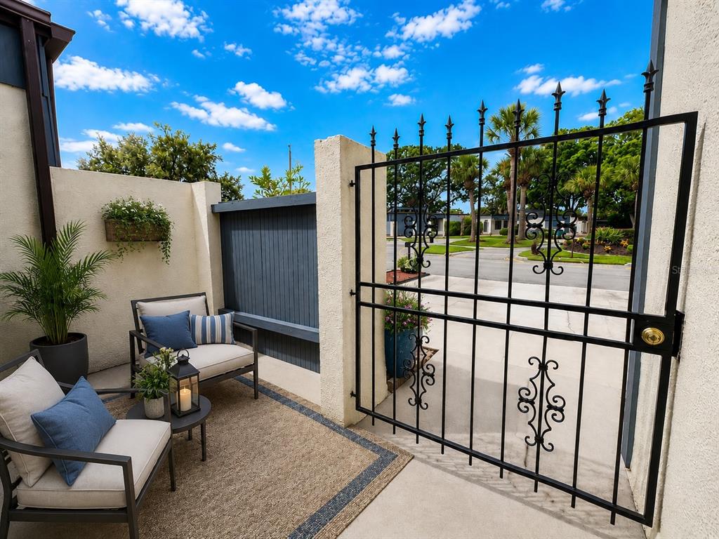 A small patio features two chairs, a side table, and a black metal gate — 2653 CAYMAN WAY, WINTER PARK, FL