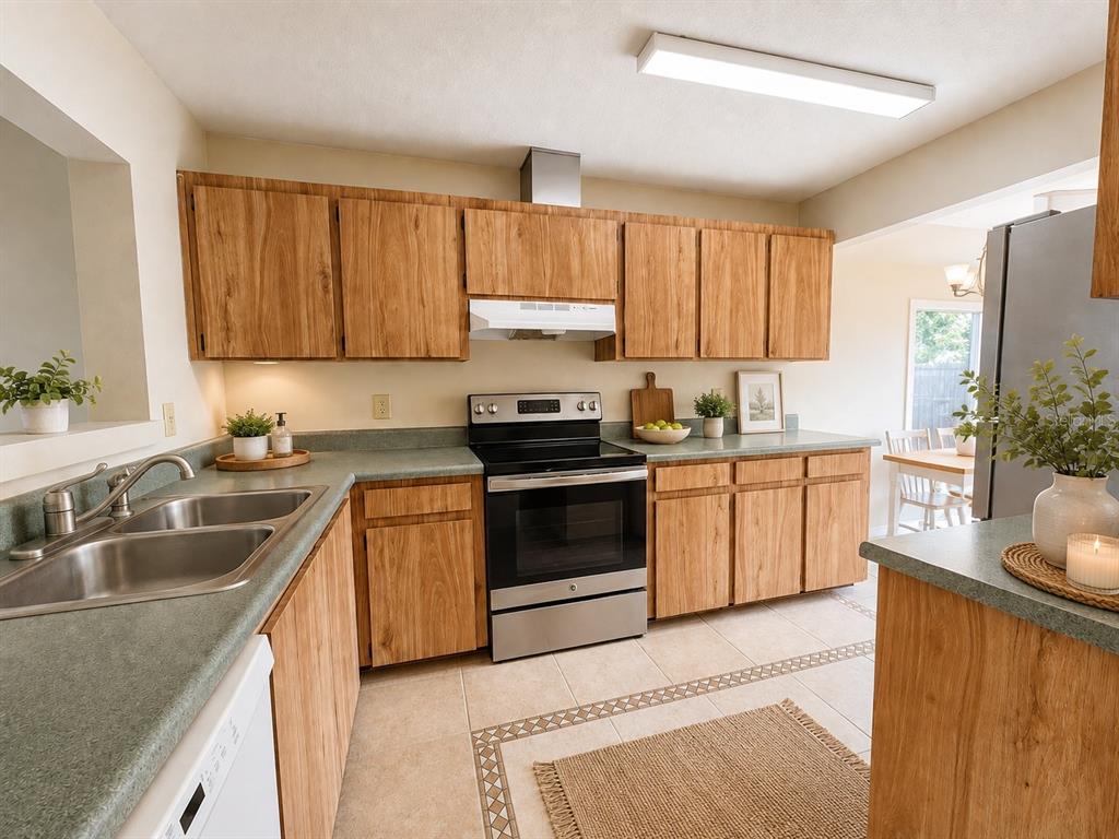 A kitchen with wood cabinets, green countertops, stainless steel appliances, and tile flooring — 2653 CAYMAN WAY, WINTER PARK, FL