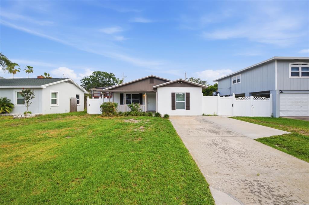 A single-story house with a white exterior, brown roof, and a concrete driveway — 1842 SHORE ACRES BOULEVARD NE, ST PETERSBURG, FL