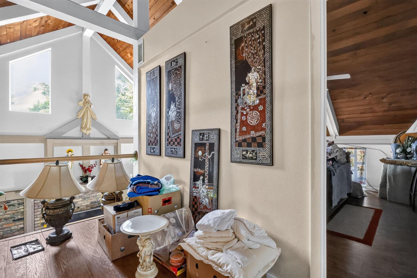 A lofted area features vaulted wood ceilings, wall art, and a view of the room below — 6022 Western Way, Lake Worth FL 33463, LAKE WORTH, FL