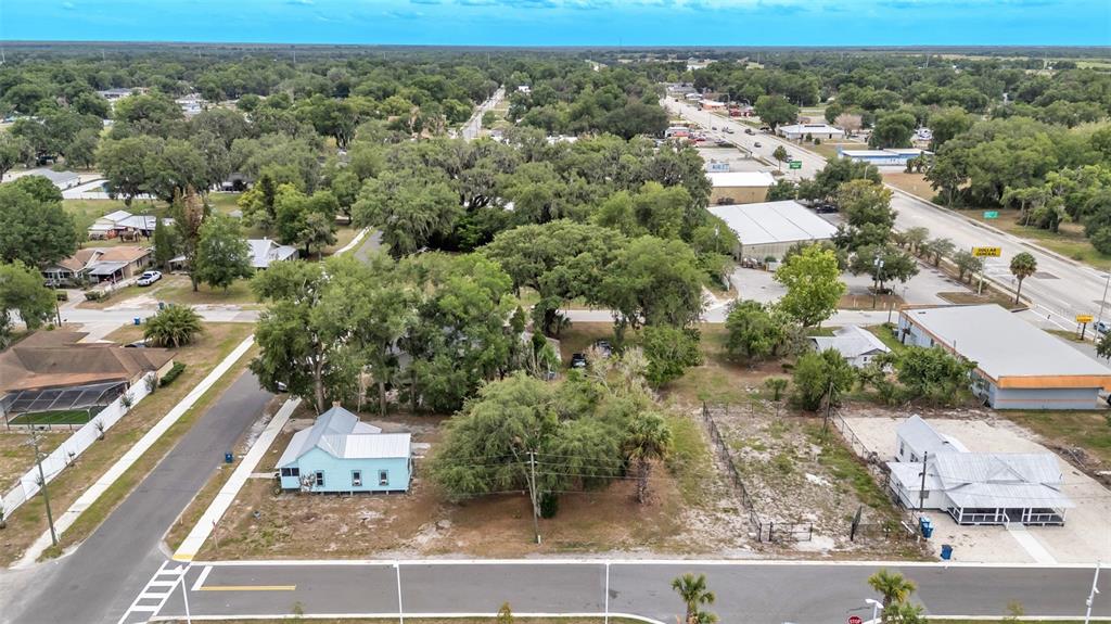 An aerial view shows two small houses on adjacent lots near a commercial road — 20 S LANIER AVENUE, FORT MEADE, FL