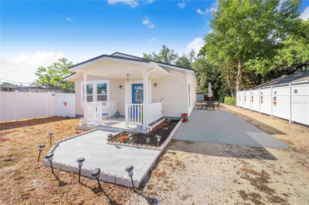A small, light-colored house with a front porch, a paved walkway, and a white fence — 3420 AVENUE T NW, WINTER HAVEN, FL