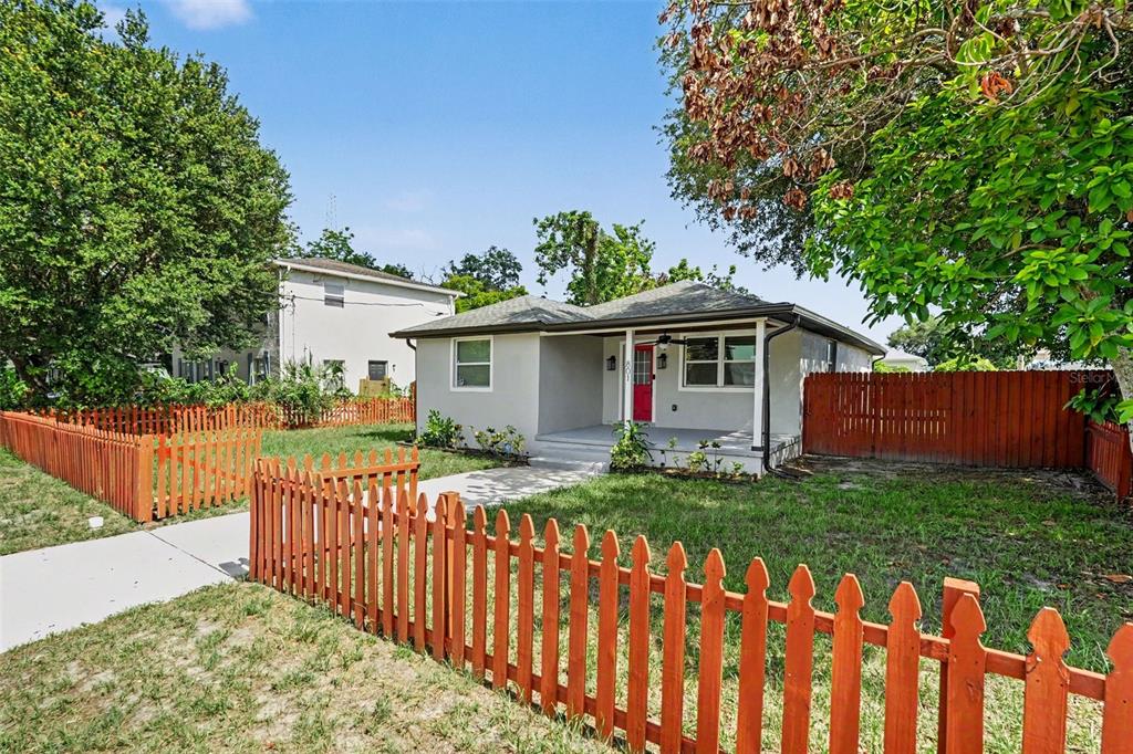 A single-story house with a red front door and a wooden picket fence — 801 E BAKER STREET, TAMPA, FL