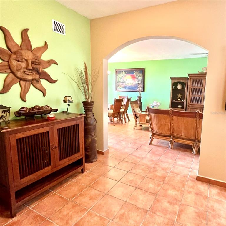A wooden cabinet and sun wall art sit in a foyer leading to a living area — 22-01 COND. RIO MAR VILLAGE UNIT #22-01, RIO GRANDE, PR
