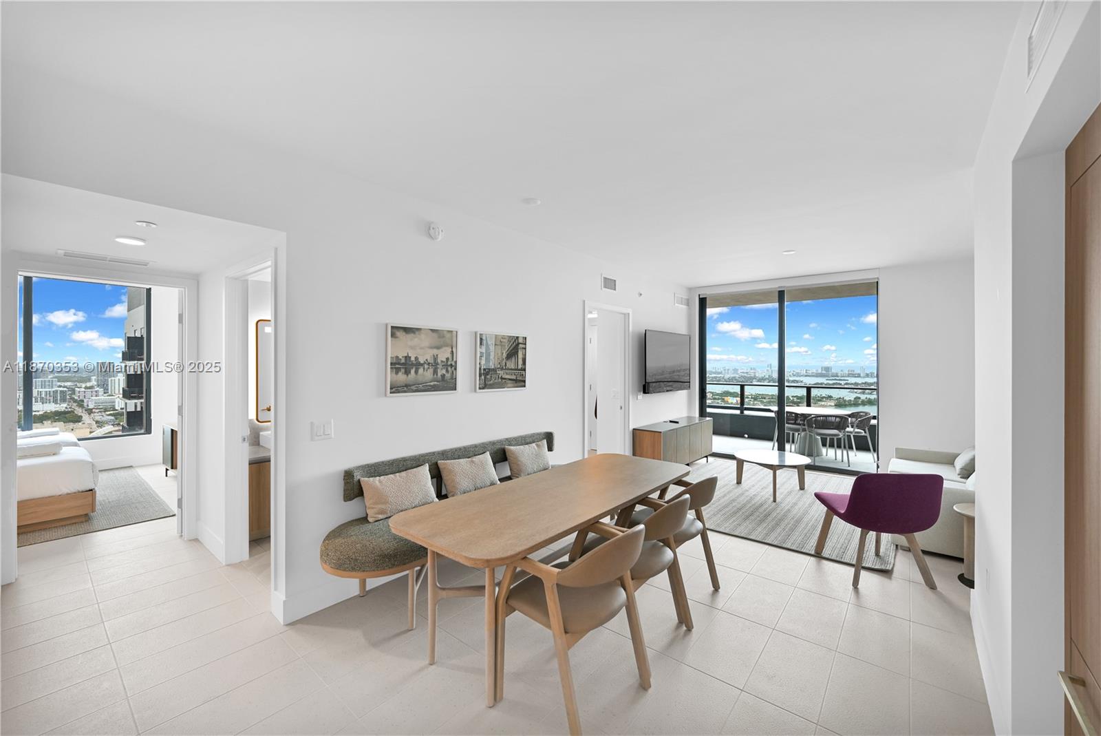 A modern dining and living area features a wooden table, bench seating, and balcony views — 159 NE 6th St # 4015, Miami FL 33132, MIAMI, FL