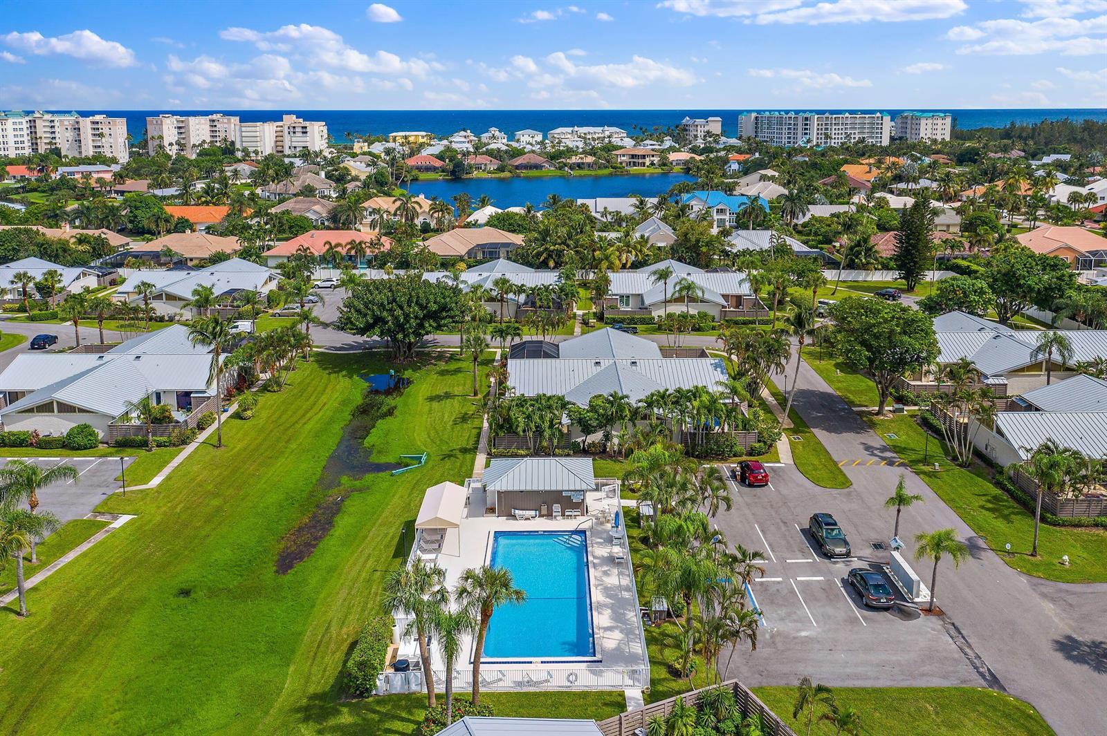 An aerial view of a residential community featuring a swimming pool, parking lot, and lake — 1801 S Us Highway 1 # 13a, Jupiter FL 33477, JUPITER, FL