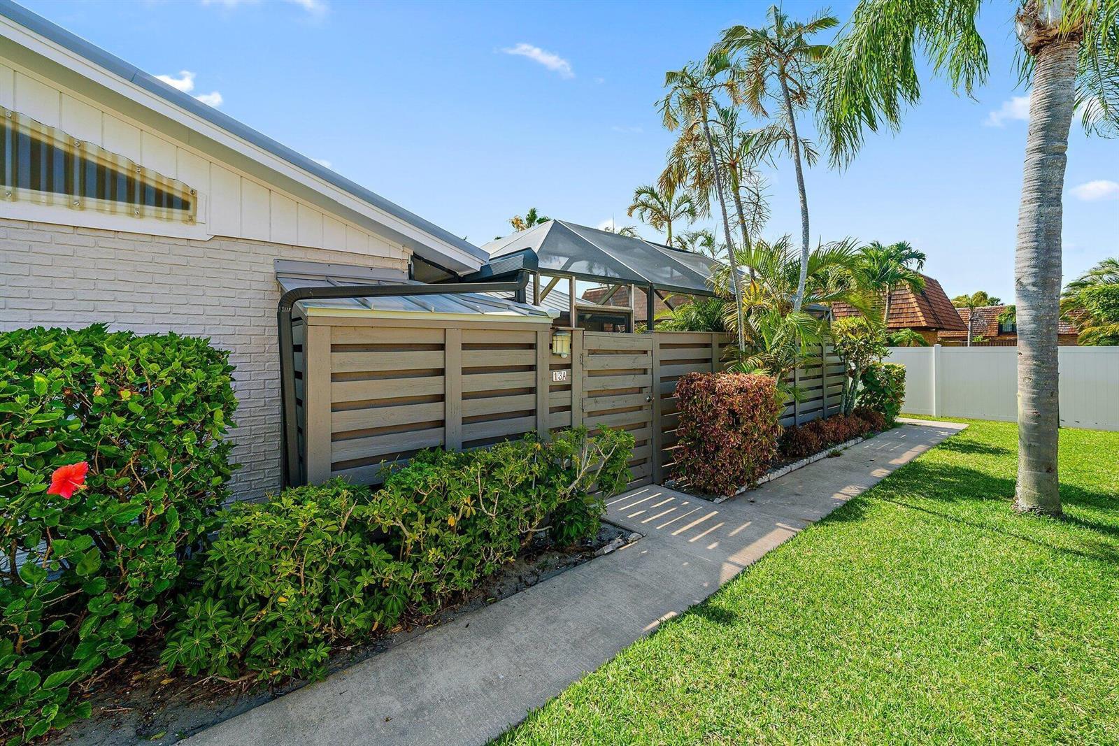 A walkway leads to a gated entrance with a privacy fence beside a brick house — 1801 S Us Highway 1 # 13a, Jupiter FL 33477, JUPITER, FL