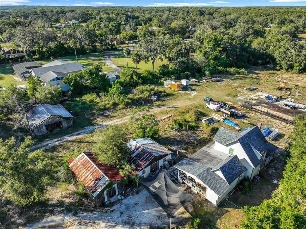 An aerial view shows a rural property with a house, several outbuildings, and scattered equipment — 7717 CLARCONA OCOEE ROAD Lot 1, ORLANDO, FL