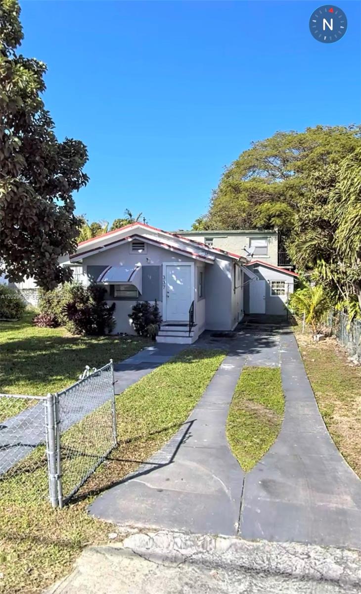 A single-story house with a gray exterior, a white front door, and a concrete driveway — 337 NE 56th St, Miami FL 33137, MIAMI, FL