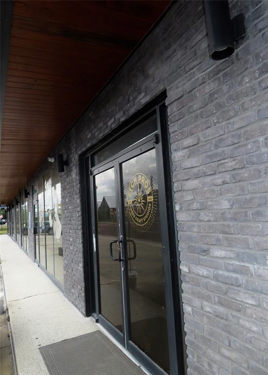 A storefront entrance features a dark brick facade, glass double doors, and a wood-paneled ceiling — 4907 N FLORIDA AVENUE, TAMPA, FL