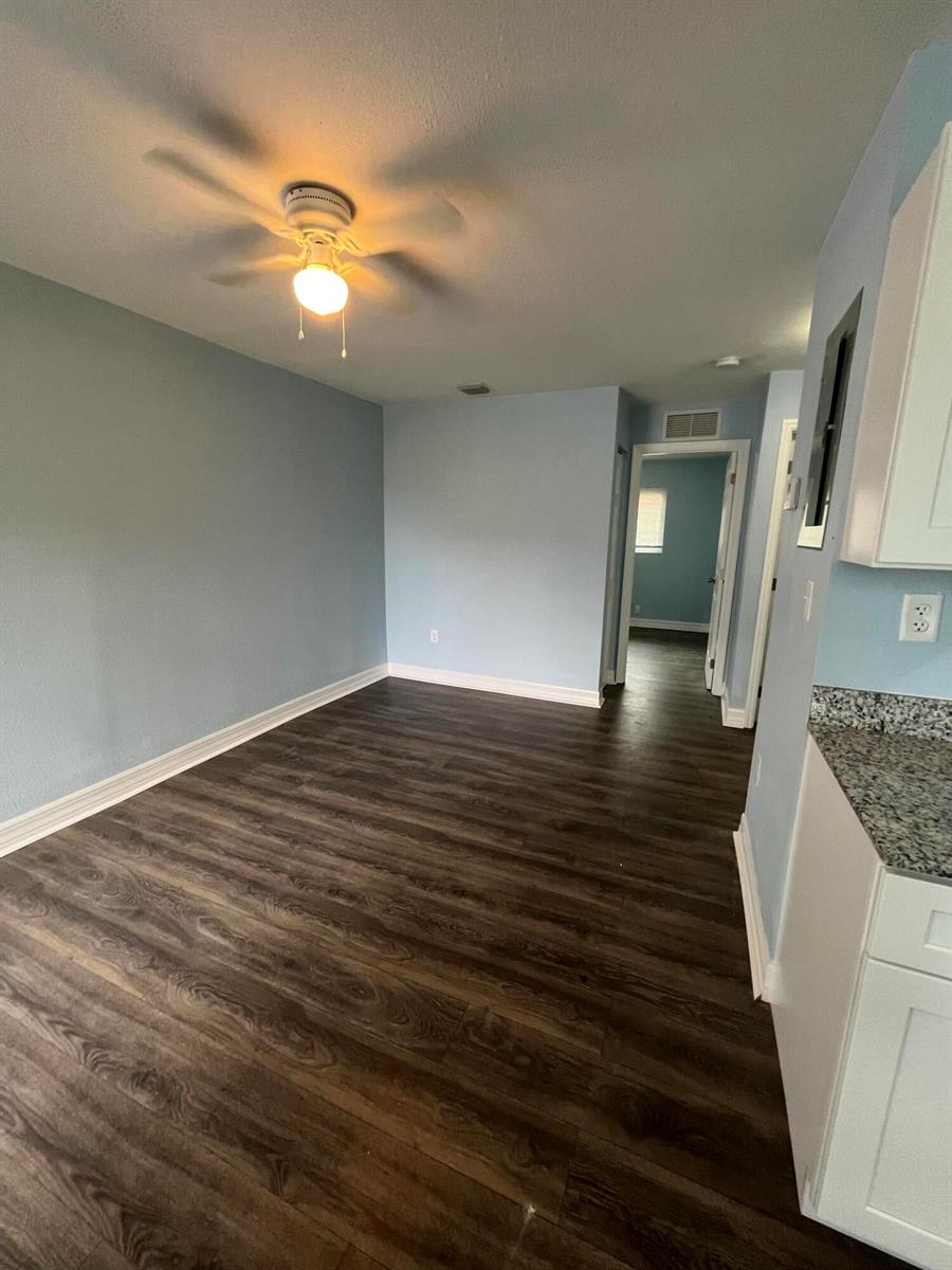 A room with light blue walls, dark wood-look flooring, and a ceiling fan — 1109 NW 6th Avenue Apt 1, Pompano Beach FL 33060, POMPANO BEACH, FL