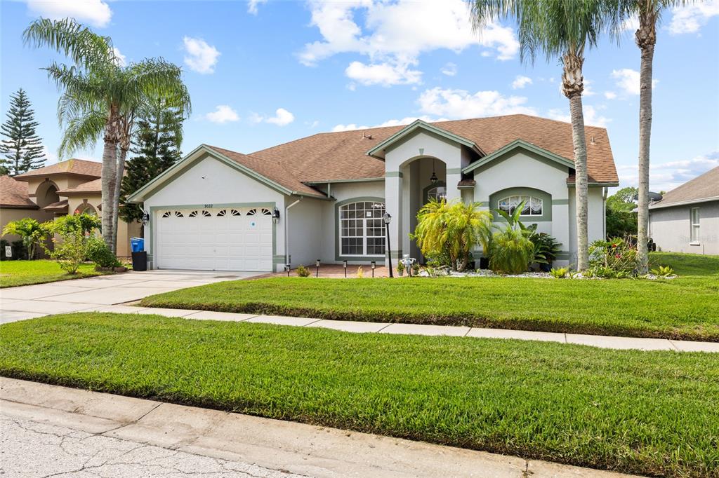 A single-story house with a white stucco exterior, a two-car garage, and palm trees — 9022 WESTBAY BOULEVARD, TAMPA, FL