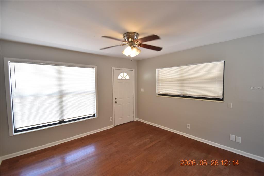 A room with hardwood floors, a ceiling fan, two windows with blinds, and a door — 4414 W WYOMING AVENUE, TAMPA, FL