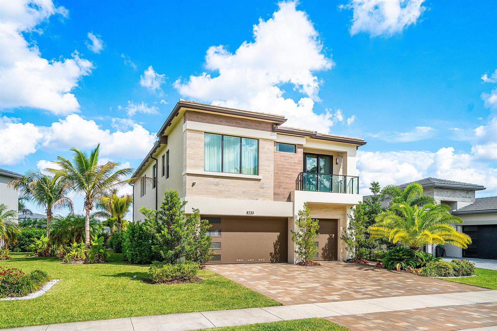 A two-story modern house features a paved driveway, a two-car garage, and a balcony — 8233 Crystal Downs Avenue, Boca Raton FL 33434, BOCA RATON, FL