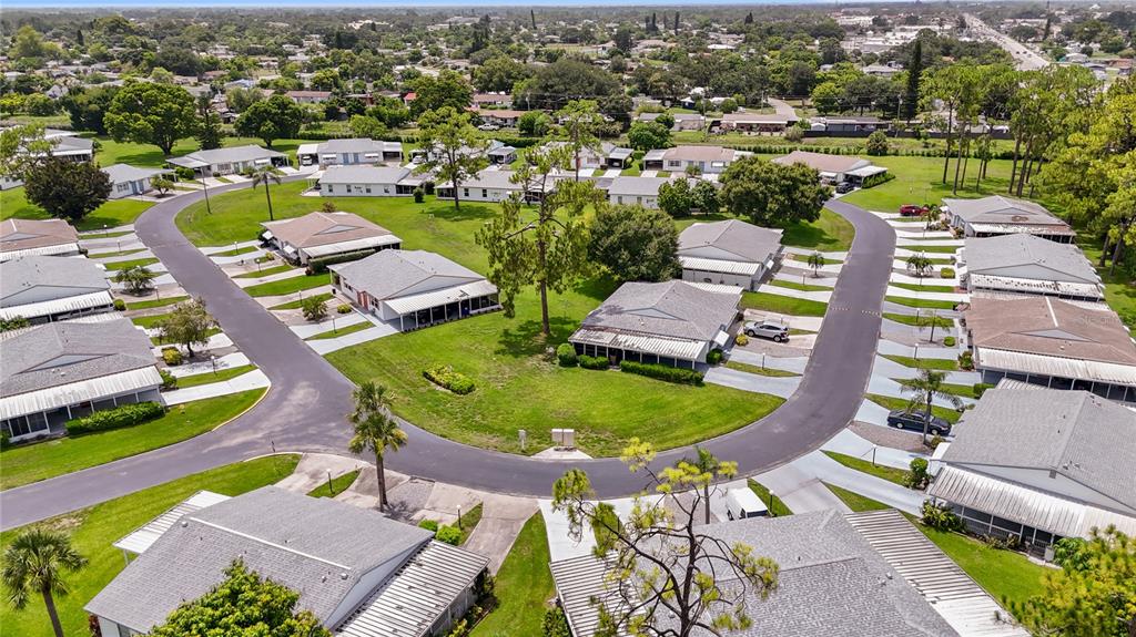 An aerial view shows a residential neighborhood with single-story homes and paved streets — 11 DESERT CANDLE CIRCLE, LEHIGH ACRES, FL