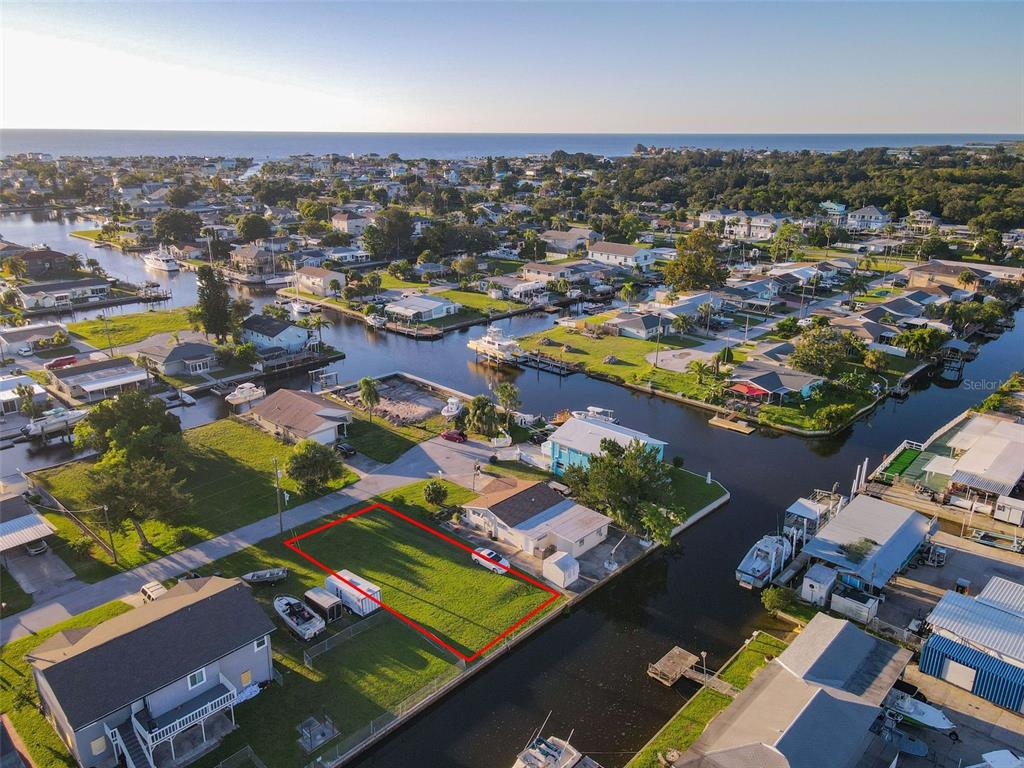 An aerial view shows a vacant waterfront lot outlined in red next to a house — Lot 33 JUDY AVENUE, HUDSON, FL