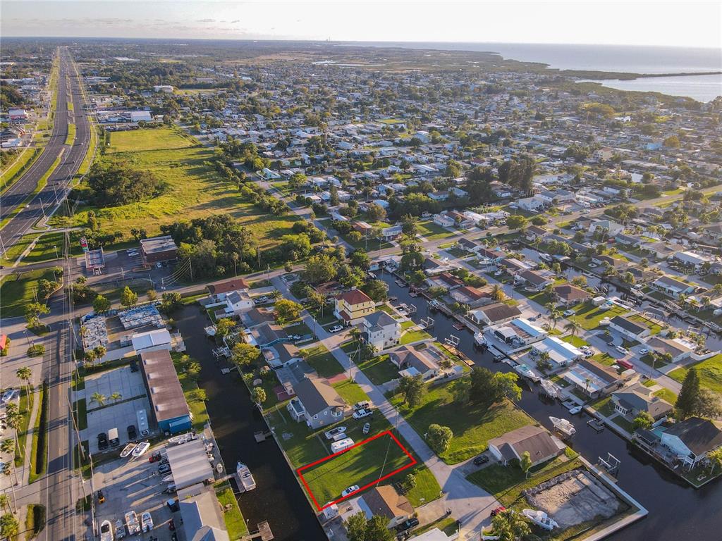 An aerial view shows a vacant rectangular waterfront lot outlined in red in a residential neighborhood — Lot 33 JUDY AVENUE, HUDSON, FL
