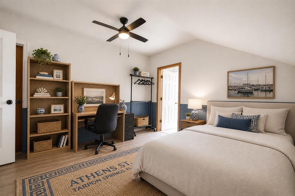 A bedroom features a bed, a desk with a chair, shelving, and blue wainscoting — 531 ATHENS STREET, TARPON SPRINGS, FL