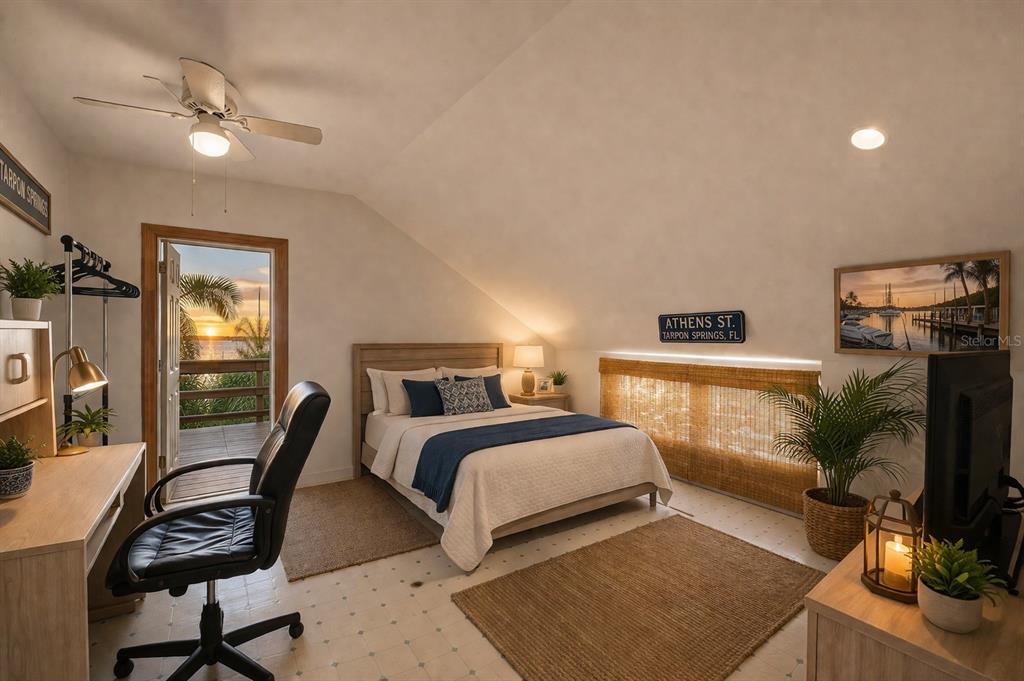 A bedroom with a desk, a bed, and a door opening to a waterfront balcony — 531 ATHENS STREET, TARPON SPRINGS, FL