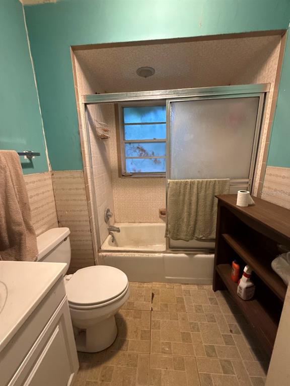 A bathroom features a tub-shower combination, a toilet, a vanity, and a wooden storage shelf — 301 W LEMON STREET, BOWLING GREEN, FL
