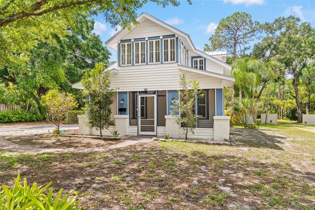A two-story house with white siding, blue trim, and a screened-in front porch — 904 W HENRY AVENUE, TAMPA, FL