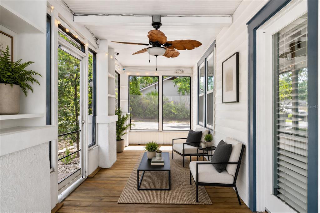 A sunroom features a wooden floor, a ceiling fan, two chairs, and a coffee table — 904 W HENRY AVENUE, TAMPA, FL
