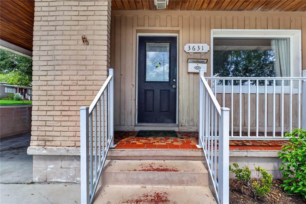 The front entrance features a black door, white railings, and a brick-accented exterior wall — 3631 CLEVELAND HEIGHTS BOULEVARD, LAKELAND, FL
