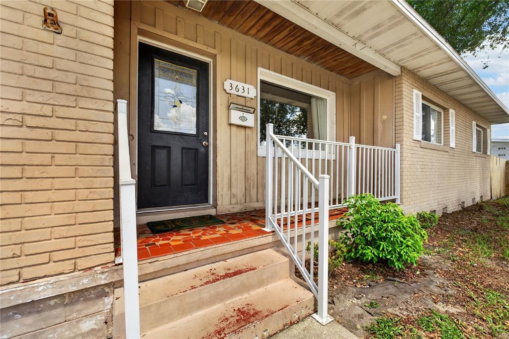The exterior of a house features a brick facade, a black front door, and stairs — 3631 CLEVELAND HEIGHTS BOULEVARD, LAKELAND, FL