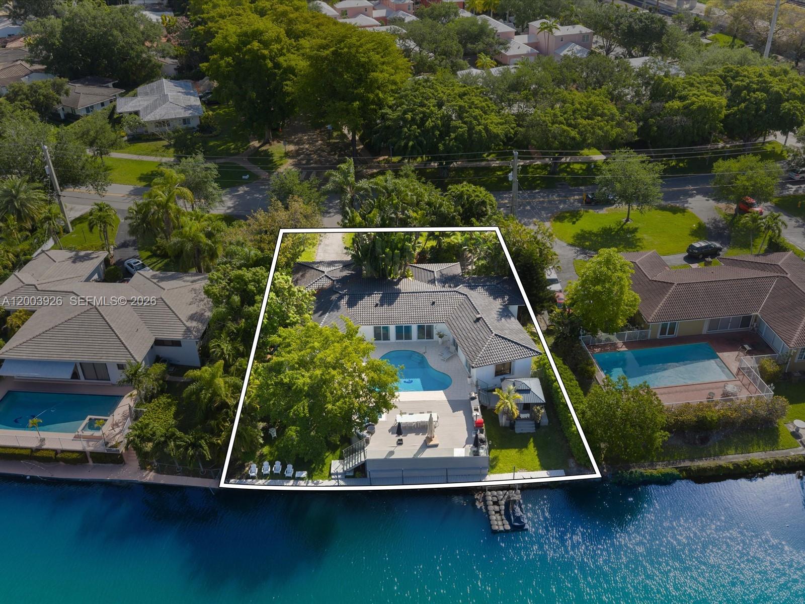 An aerial view shows a waterfront house with a pool, deck, and dock — 5000 Riviera Dr, Coral Gables FL 33146, CORAL GABLES, FL