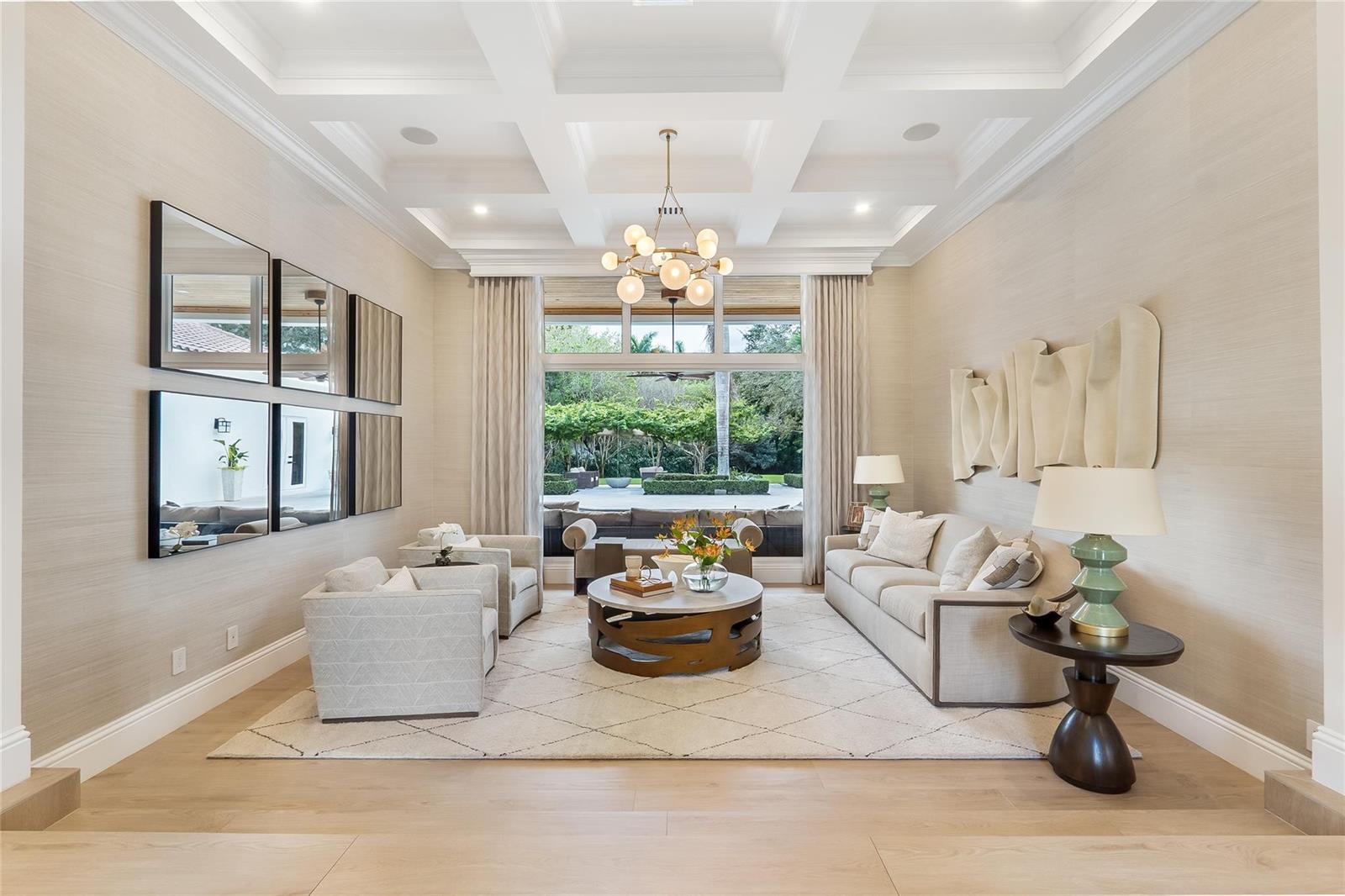 A living room features a coffered ceiling, neutral furniture, and a large window overlooking a patio — 2825 Hackney Road, Weston FL 33331, WESTON, FL